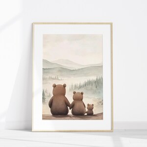May include: Framed watercolour print depicting a bear family looking at a misty mountain scene. The bears, in shades of brown, are seen from behind. The artwork is in a light wood frame, evoking a sense of family and nature.