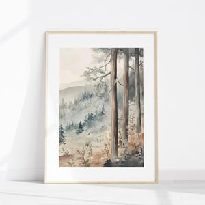 May include: Watercolour painting of a forest scene in a wooden frame. The artwork depicts tall trees in the foreground with a misty mountain landscape in the background. The colour palette includes shades of grey, brown, and green.