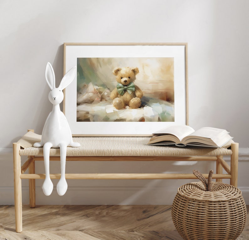 May include: A framed print of a teddy bear with a green bow tie sits on a bench. A white ceramic rabbit and an open book are also on the bench. A woven basket with an apple-shaped lid is on the floor.