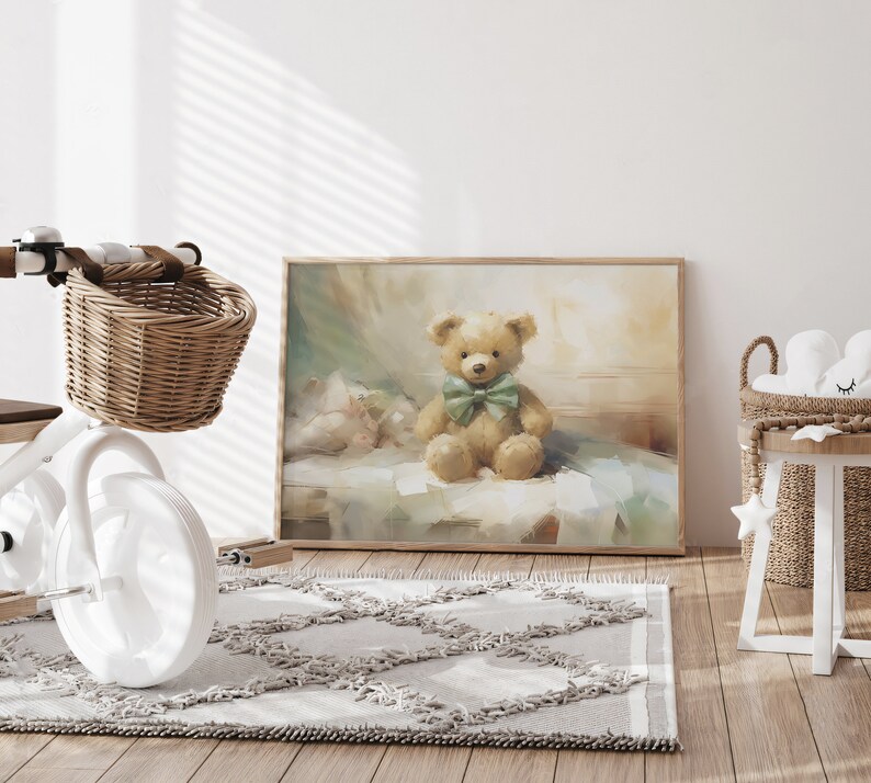 May include: A framed print of a teddy bear with a green bow tie. The artwork has a soft, painterly style with muted colors. The print is displayed in a child's room with a white tricycle and a woven basket.