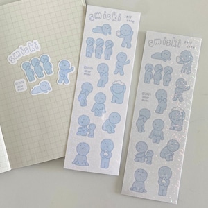 May include: Two sheets of stickers featuring illustrations of small blue figures in various poses. The stickers are labelled "smiski self care" and include the copyright information "©2024 dear mimi".