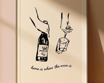 以下が含まれることがあります： ワインボトルとワイングラスの白黒線画プリント。イラストの下には「home is where the wine is」というフレーズが書かれています。アートワークは白いフレームで額装されています。