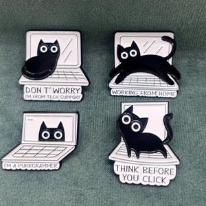 以下が含まれることがあります： ラップトップをテーマにした言葉遊びが書かれた、漫画の猫が描かれた黒と白のエナメルピン4個セット。ピンには、「心配しないで、私はテクニカルサポートです」、「在宅勤務」、「私はプログラマーです」、「クリックする前に考えてください」と書かれています。