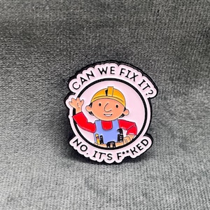 Könnte beinhalten: Eine schwarz-weiße Emaille-Anstecknadel mit einer Comicfigur, die einen gelben Helm und ein rotes Hemd trägt. Die Anstecknadel lautet "Can we fix it? No. It's f**ked."