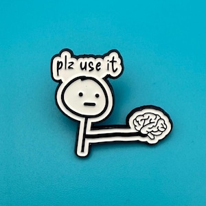 Op de afbeelding: Een zwart-witte pin met een stokfiguur met de tekst "plz use it" boven zijn hoofd. De stokfiguur steekt zijn arm uit naar een hersen. De pin staat op een blauwe achtergrond.