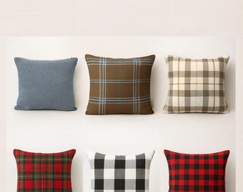 Op de afbeelding: Zes vierkante kussenslopen met ruit- en textuurontwerpen. De kussens zijn in verschillende kleuren, waaronder blauw, bruin, wit, rood en zwart. De tekst "Plaid & Textured Pillow Covers" staat bovenaan.