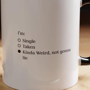 May include: White ceramic mug with black text that reads "I'm: Single, Taken, Kinda Weird, not gonna lie".
