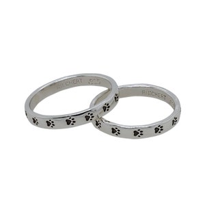 two silver rings with paw prints stamped onto them