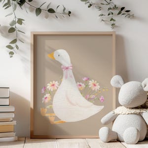 May include: A watercolor illustration of a white goose with a pink bow sitting on a beige background with pink and yellow flowers.