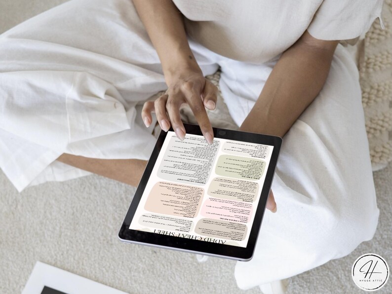 May include: A digital tablet displaying a printable "Adult Cheat Sheet" with a colourful design. The sheet is divided into sections with text and bullet points.