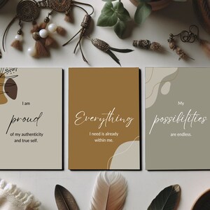 May include: Three printable wall art prints with abstract shapes and inspirational quotes. The first print is beige with brown shapes and the quote "I am proud of my authenticity and true self." The second print is brown with a white quote "Everything I need is already within me." The third print is green with a white quote "My possibilities are endless."