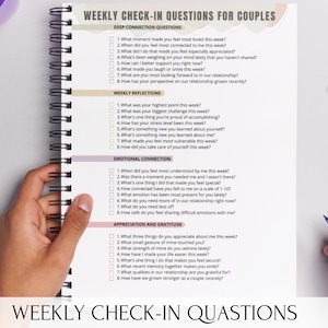 Può includere: Un quaderno a spirale con un questionario di controllo settimanale per coppie. Il quaderno aperto rivela domande sulla connessione profonda, le riflessioni settimanali, la connessione emotiva e l'apprezzamento. Una mano tiene il quaderno e l'altra una penna.