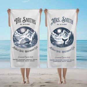 May include: Two white beach towels with a navy blue Alaskan Cruise design. One towel reads "The Smiths" and the other "Mrs. Smith". Each features a cruise ship or whale tail illustration, mountains, and the text "Carnival Spirit 2025".