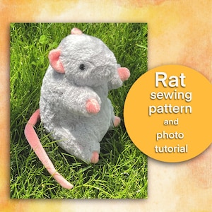 Puede incluir: Un juguete de peluche gris en forma de rata con orejas y cola rosas, sentado en un lecho de hierba verde. La imagen incluye el texto "Rat sewing pattern and photo tutorial".