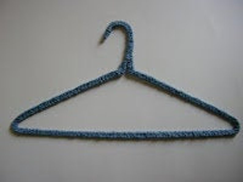 Image of a wire hanger covered in blue yard crocheted around it.