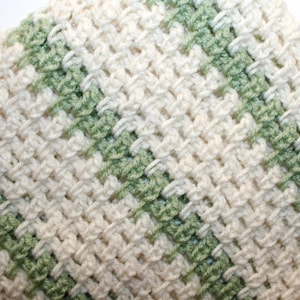 Peut inclure: Une couverture au crochet avec un motif diagonal de rayures vertes et blanches.