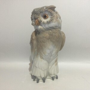 May include: A ceramic owl figurine in shades of gray, brown, and white. The owl has large, round eyes and detailed feather textures. The figurine is standing upright, showcasing its detailed features.