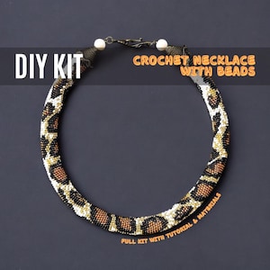 May include: DIY kit for a crochet necklace with beads. The necklace is made with black, white, gold, and brown beads in a leopard print pattern. The kit includes all the materials and instructions needed to make the necklace.