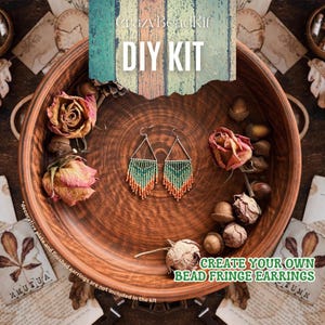 Könnte beinhalten: DIY-Set zum Erstellen eigener Perlen-Fransenohrringe. Das Set enthält grüne, orange und braune Perlen sowie silberne Ohrhaken. Die Ohrringe werden in einer Holzschale mit getrockneten Blumen und Eicheln präsentiert.