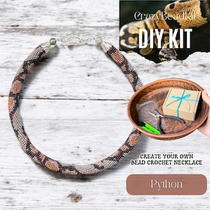 May include: A handmade bead crochet necklace with a snake-like pattern in shades of gray, black, and orange. The necklace is displayed with a DIY kit containing tools and materials to create a similar necklace. The text "CrazyBeadkit DIY KIT" is visible.