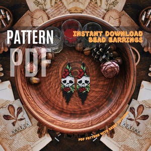 May include: A digital download pattern for beaded skull earrings. The pattern includes instructions for creating the earrings, which feature a skull design with red roses and green leaves. The earrings are shown on a wooden plate with a rustic background.