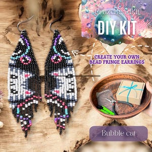 Puede incluir: Dos pendientes de flecos de cuentas con un patrón negro, blanco, gris, rosa y morado. Los pendientes forman parte de un kit de bricolaje, con el texto "DIY KIT" y "CREATE YOUR OWN BEAD FRINGE EARRINGS". El kit incluye herramientas y materiales. Los pendientes están etiquetados como "Bubble cat".