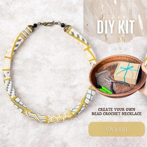 May include: A handcrafted beaded crochet necklace featuring a white, gold, and navy blue geometric design. The image includes a DIY kit with tools and materials for making a similar necklace. The text "CrazyBeadKit DIY KIT" is displayed.