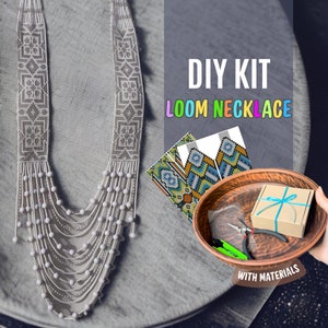 May include: DIY kit for a loom necklace with materials included. The kit includes a pattern, beads, and tools. The finished necklace is white with a geometric design.