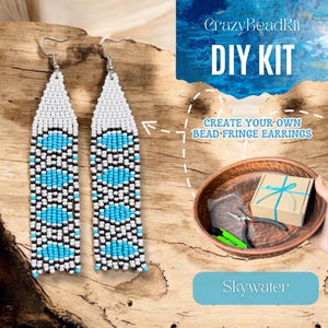 Puede incluir: Pendientes de flecos de cuentas hechos a mano en blanco, negro y azul turquesa. Los pendientes se muestran sobre una superficie de madera. La imagen también muestra un kit de bricolaje con el texto "CrazyBeadKit DIY KIT" y "CREATE YOUR OWN BEAD FRINGE EARRINGS."