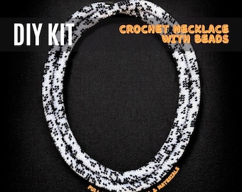May include: A DIY kit for a crochet necklace with beads. The necklace is white with black accents, and the text "DIY KIT" and "CROCHET NECKLACE WITH BEADS" are displayed. The kit includes a full kit with tutorial and materials.