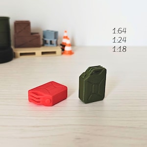 Puede incluir: Dos bidones de combustible de plástico en miniatura, uno rojo y otro verde, para modelismo. Los bidones están etiquetados con 1:64, 1:24 y 1:18.