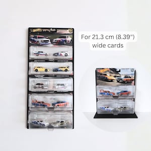 Könnte beinhalten: Schwarze Vitrine für Hot Wheels Spielzeugautos. Die Vitrine enthält mehrere Autos in ihrer Originalverpackung. Der Text auf dem Bild lautet: "For 21.3 cm (8.39") wide cards."