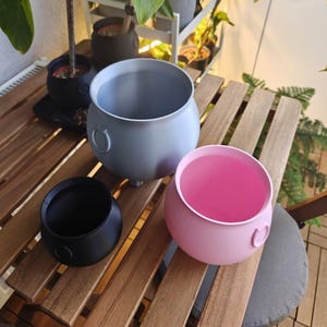 Set of cauldron planters on table, witch pot decor for home styling