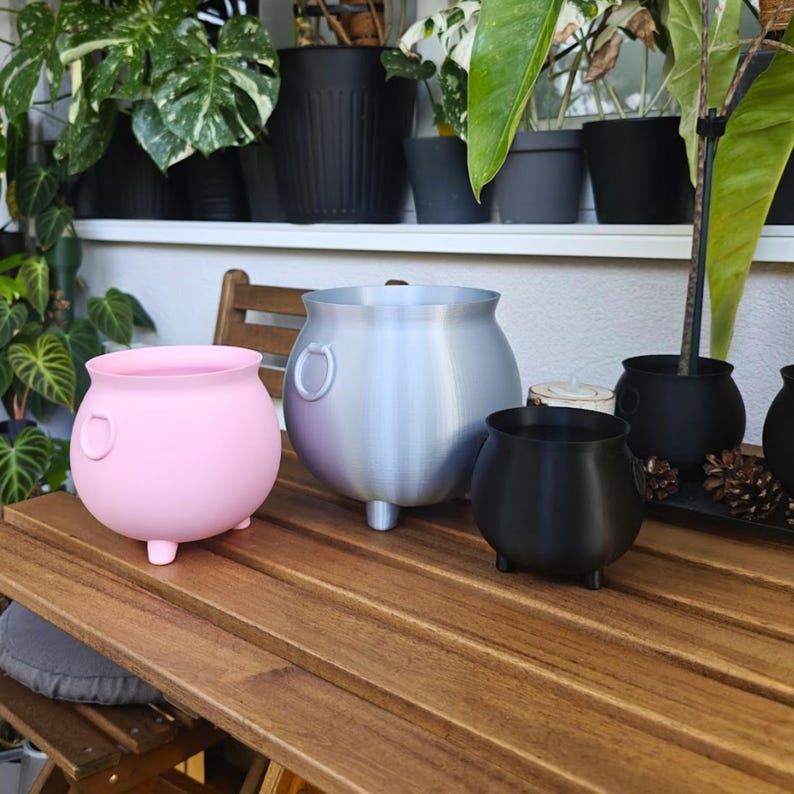 Set of cauldron planters on table, witch pot decor for home styling