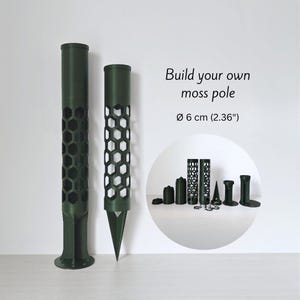 Könnte beinhalten: Zwei dunkelgrüne Moosstangen-Komponenten mit Wabenmuster, zusammen mit anderen Teilen. Der Text lautet "Build your own moss pole" und "ø 6 cm (2,36")". Diese Komponenten sind für die Pflanzenunterstützung und den Gartenbau konzipiert.