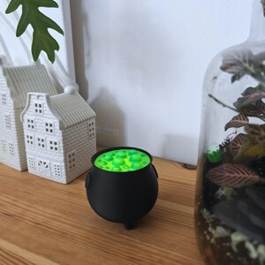 Glowing cauldron tealight holder styled with decor, enchanted witch pot aesthetic