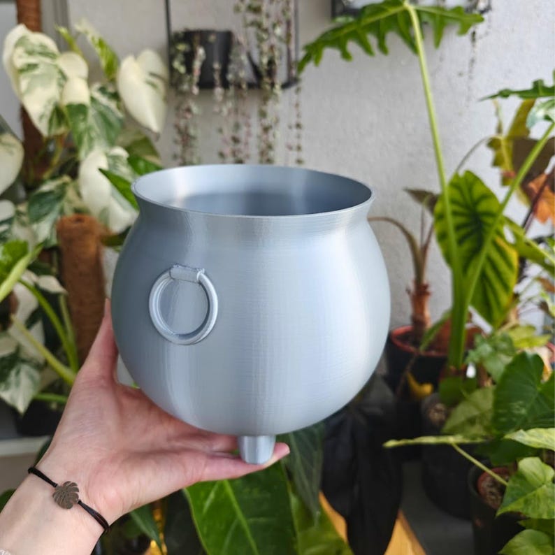 Silver cauldron planter with plant in hand, decorative gothic plant container