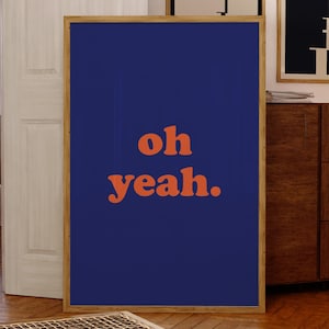 May include: A framed poster with a navy blue background and the text "oh yeah." in orange.
