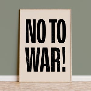 May include: A beige poster with black text that reads "NO TO WAR!" The poster is framed in a light wood frame.