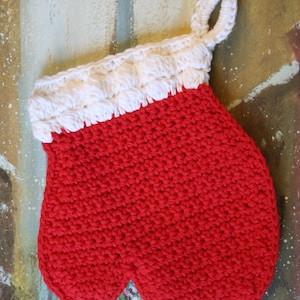 May include: Red crocheted oven mitt with a white crocheted cuff and a hanging loop.