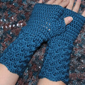 May include: A pair of teal blue crocheted fingerless gloves with a textured pattern.