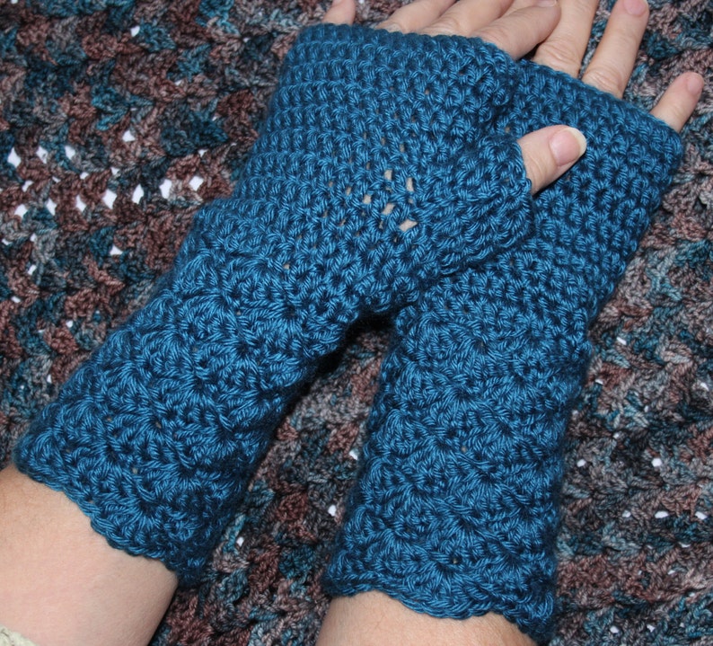 May include: A pair of teal blue crocheted fingerless gloves with a textured pattern.