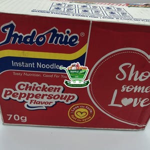 May include: A red box of Indomie instant noodles with Chicken Peppersoup flavor. The box features the brand name in blue and yellow, with the flavor description in white. The box contains 70g of noodles.