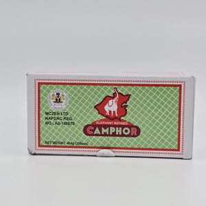 May include: A white box with green and red accents. The box contains Elephant Refined Camphor. The box has the text "MCZEN LTD", "NAFDAC REG.", "NO.: A2-100670", "ELEPHANT REFINED", "CAMPHOR", and "NET WEIGHT: 454g (256pcs)".