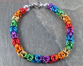 May include: A rainbow colored chainmail bracelet with a silver clasp.
