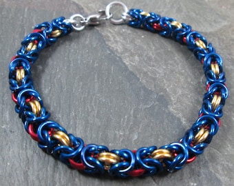 May include: A blue, red, and gold chainmail bracelet with a silver clasp.