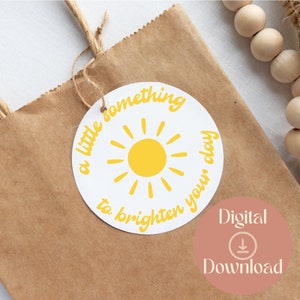 May include: A white circle tag with a yellow sun and the text "a little something to brighten your day".