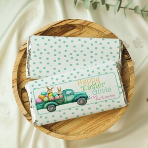 May include: A green and white polka dot chocolate bar wrapper with a green truck carrying Easter bunnies and eggs. The wrapper says "Happy Easter Olivia Love Aunt Renee".