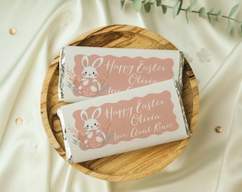 May include: Two white chocolate bar wrappers with pink bunny illustrations and the text "Happy Easter Olivia" and "Happy Easter Olivia Love Aunt Renee".