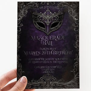 May include: Purple masquerade ball invitation with a silver mask and ornate silver border. The text reads "Please join us for Masquerade Ball in honor of Maria's 20th Birthday Saturday the 14th of November at eight o'clock in the evening Lakeside Country Club 123 Lake Lane Golden, CO"